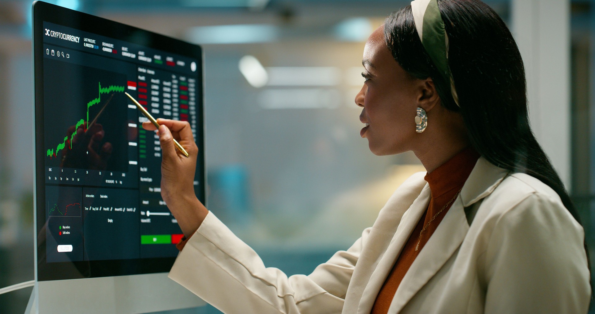 Woman, monitor and trading graphs at office, point and review growth with info at finance agency. African person, investor and computer screen with fintech for stats, portfolio and charts at company